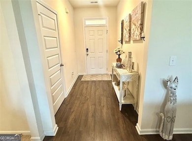 Entryway featuring dark wood-style floors, visible vents, and baseboards