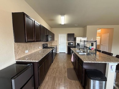 Kitchen with black appliances, wood finished floo
