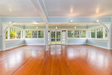Large open concept living and dining room with original windows and flooring