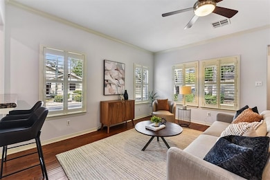 Living area featuring ornamental molding, wood finished floors, and ceiling fan