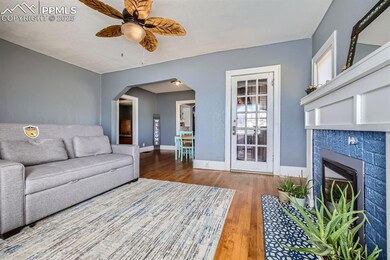 Living room featuring ceiling fan, a tile fireplac