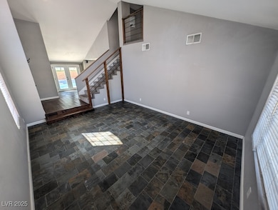 Unfurnished living room with stairway, baseboards,
