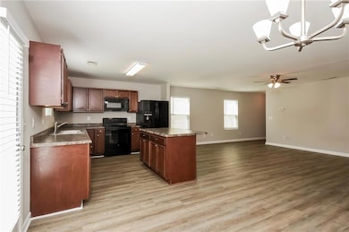 Kitchen with a center island, black appliances, li