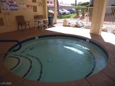 View of pool with fence, a community hot tub, and