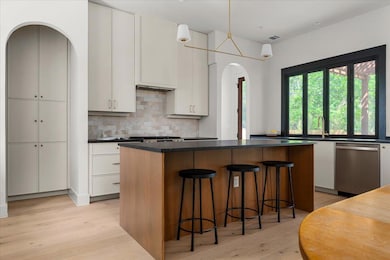 Kitchen with light wood-style floors, arched walk