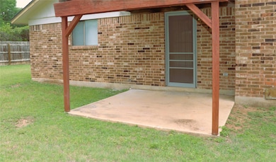 View of exterior entry featuring a yard, brick si