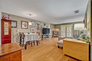 The large family and dining room combo is bright with garden and pool views.