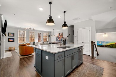 Kitchen featuring gray cabinetry, crown molding, a sink, and dark wood-style flooring