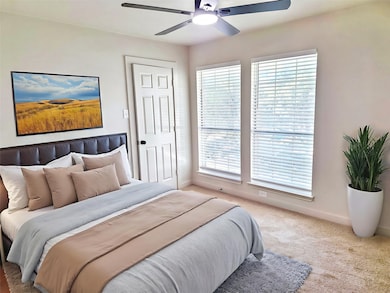 Carpeted bedroom with baseboards and a ceiling fan