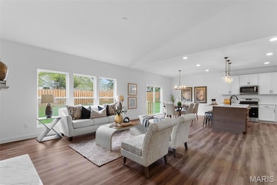 Living room with recessed lighting, lofted ceiling, dark wood-style floors, and a chandelier