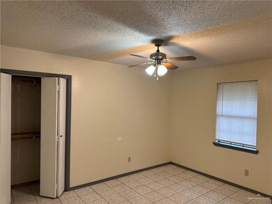 Unfurnished bedroom with a closet, a textured ceiling, and a ceiling fan