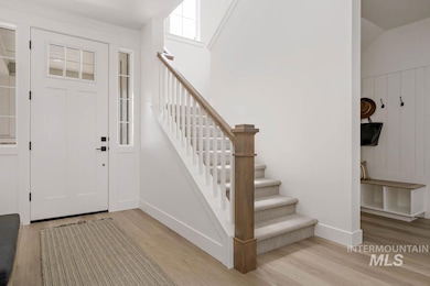 Entrance foyer with light wood-style floors and stairs