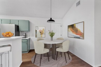 Dining area with dark wood-style floors, baseboar