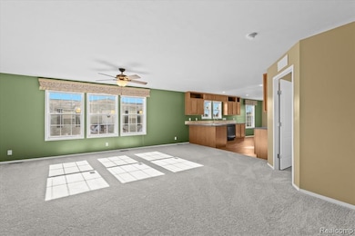Unfurnished living room with ceiling fan and light carpet