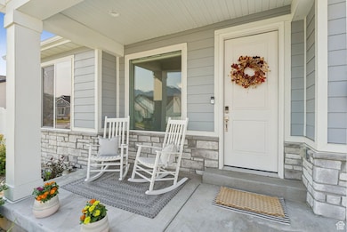 View of exterior entry featuring stone siding and covered porch