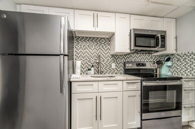 Kitchen with light stone counters, a sink, stainle