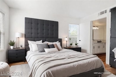 Bedroom featuring dark wood-type flooring and ensuite bathroom
