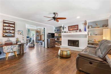 Living room featuring a ceiling fan, crown molding