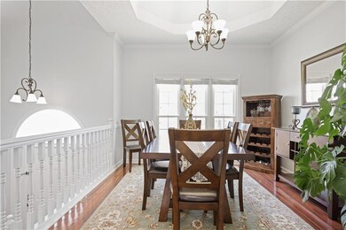 Dining room with wood finished floors, a raised ce