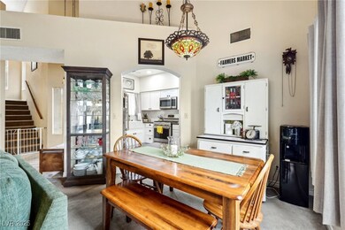 Dining space with light colored carpet, arched wal