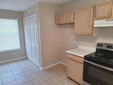 Kitchen with electric stove, light tile patterned 