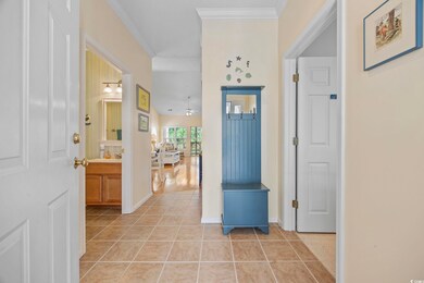 Tiled foyer featuring ornamental molding and ceili