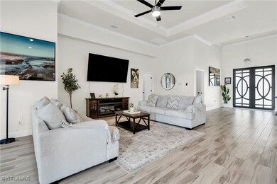 Living area featuring a ceiling fan, light wood-ty