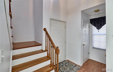 View of front door, main floor bath and stairs leading to the second floor