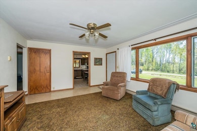 Sitting room with baseboards, baseboard heating, and a ceiling fan