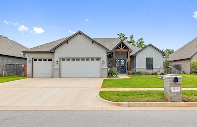 View of front of house with an attached garage, stucco siding, concrete driveway, a front lawn, and brick siding