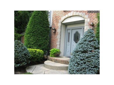 The beautifully landscaped brick, stone, & cedar h