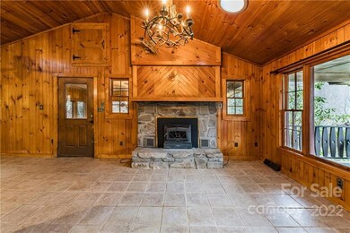 Classic mountain cabin aesthetic. Main entrance to left of the wood stove.