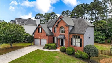 Traditional-style home featuring brick siding, driveway, an attached garage, and roof with shingles