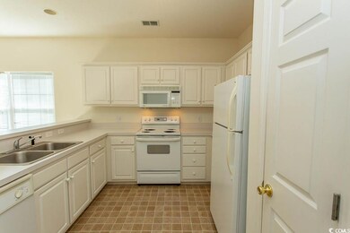 Kitchen featuring white appliances, sink, and whit