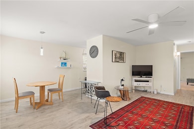 Living area with light wood-style flooring and ceiling fan