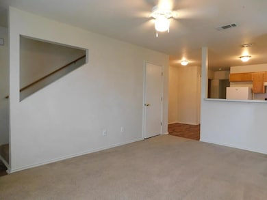 Unfurnished living room with light colored carpet and baseboards