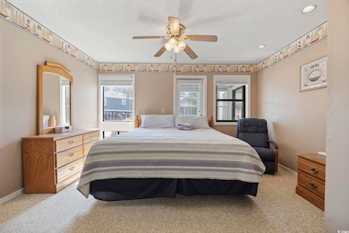 Bedroom with a ceiling fan, baseboards, a textured