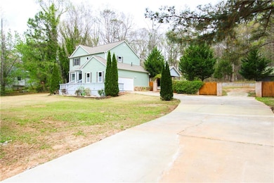 View of side of property featuring concrete driveway and an attached garage