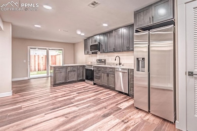 Kitchen featuring stainless steel appliances, recessed lighting, light wood-style flooring, and a peninsula
