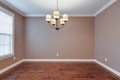 Empty room with ornamental molding, dark hardwood 