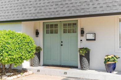 Property entrance with stucco siding and roof with
