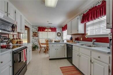 Sunny kitchen with pantry, tile floor, Kenmore stove, Samsung microwave & Kenmore dishwasher