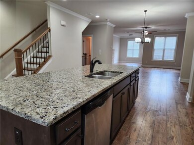 Kitchen with ornamental molding, stainless steel dishwasher, wood-type flooring, recessed lighting, and dark brown cabinets
