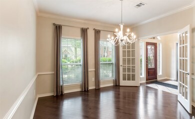 Formal dining has wood flooring and french doors.