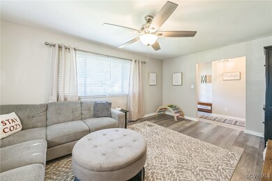 Living room with ceiling fan and wood-type floorin
