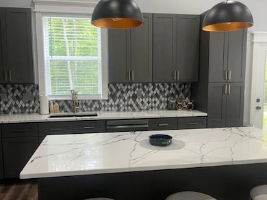 Kitchen with tasteful backsplash, a breakfast bar, light stone counters, and dishwashing machine