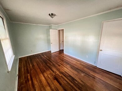 Empty room featuring ornamental molding and dark w