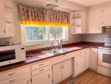 Kitchen with wood-type flooring, dark countertops,