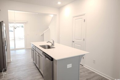Kitchen with stainless steel appliances, a sink, gray cabinetry, a chandelier, and light wood-style flooring