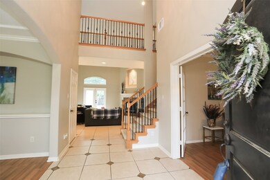 The voluminous ceilings in the foyer continue into the living room, where the upstairs catwalk overlooks the proceedings in classy form.